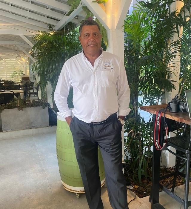 breeder of the brahman cow posing in a plant-filled restaurant