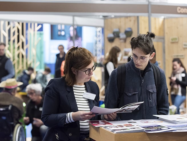 A member of staff handing a flyer to a visitor
